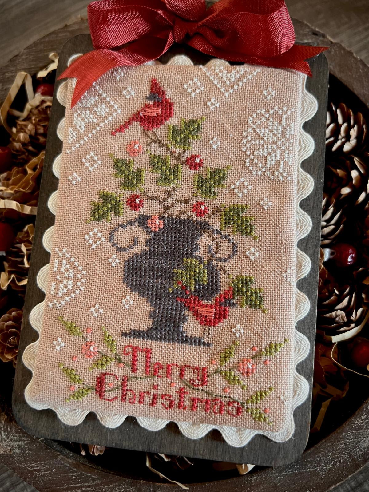 Feathers and Frost by Annie Beez Folk Art: cardinals and holly in a dark urn, Merry Christmas lettering, white trim, and a red bow.